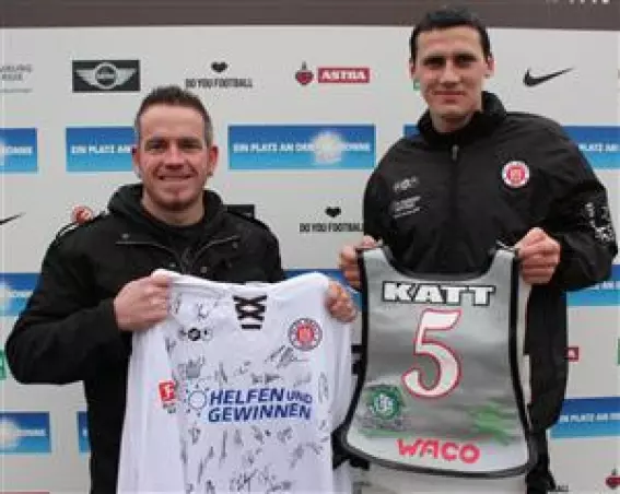 Bahnsport-Profi Stephan Katt<br>(links) und St. Pauli-Verteidiger<br>Ralph Gunesch mit den Jerseys,<br>die nun ersteigert werden können.