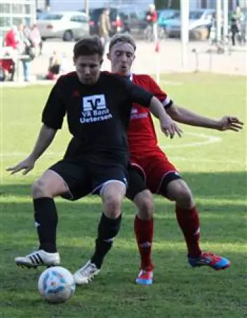 TSV-Stürmer Sascha Kuz-<br>manov (links) schirmt den<br>Ball vor einem Liether ab.