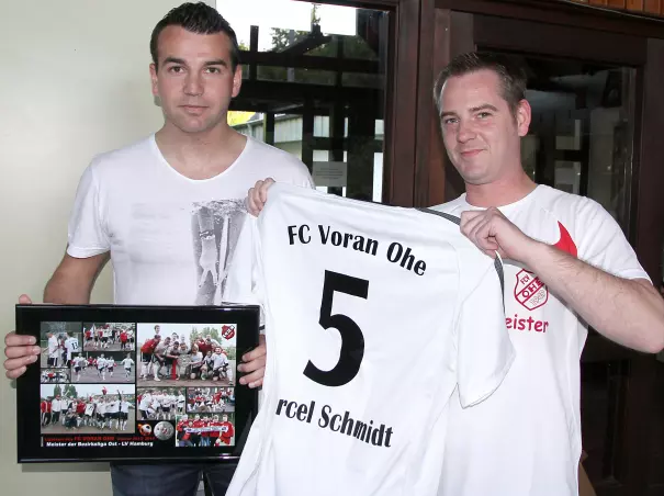 Der bisherige Voran-Kapitän Marcel<br>Schmidt (links) bekam zu seinem<br>Abschied eine Foto-Collage und ein<br>Trikot überreicht.