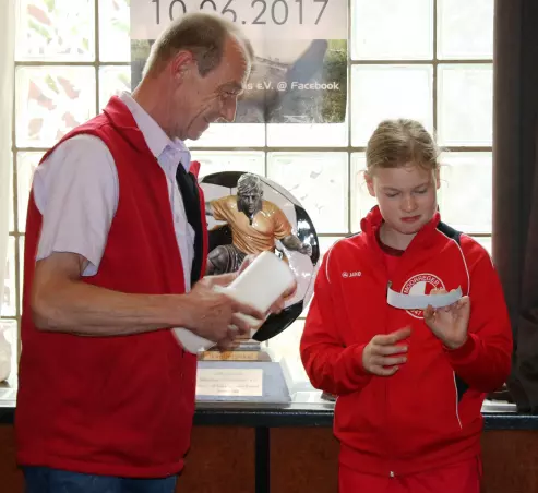Erdmann Korgoll (links), Erster Vorsitzender des Förderkreises des Moorreger Fußballs e. V., und Los-Fee Danielle Lehning bei der Auslosung.