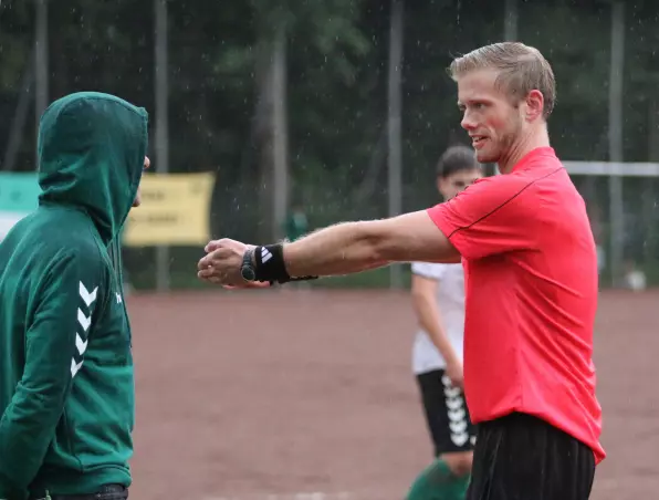 Schiedsrichter Thoms Grede (rechts) in seinem Element: Gestenreich weist er den Wedeler Trainer Jörn Großkopf zurecht, der sich mit seiner Kapuze nicht etwa vor den Worten des Referees, sondern vor dem Regen schützen wollte.