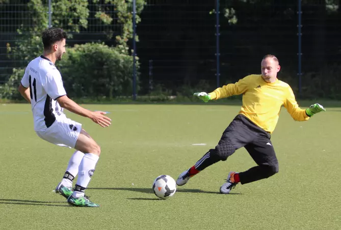 Efe Zengin (Rasensport Uetersen III, links) im Duell mit Meikel Ruhnau, dem Torwart von Hammonia III.