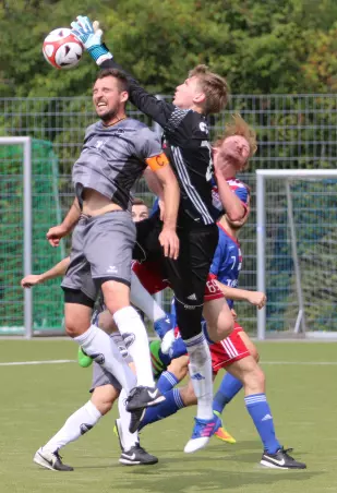 Cosmos-Keeper Till Nuppenau (im schwarzen<br>Trikot) fängt eine Flanke vor Rasensport-Kapitän<br>Philipp Ehlers ab.